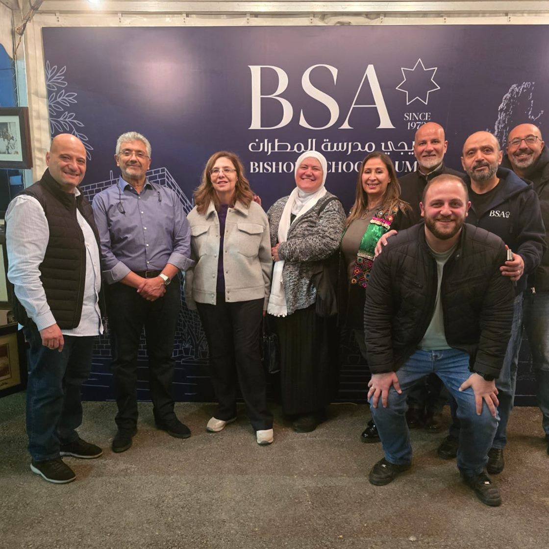 خريجو مدرسة المطران أمام خلفية النادي — Bishop's School alumni in front of the BSA backdrop